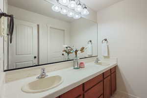 Full bath featuring double vanity, tile patterned flooring, and a sink
