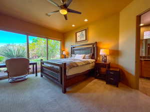 Bedroom featuring light carpet, ceiling fan.