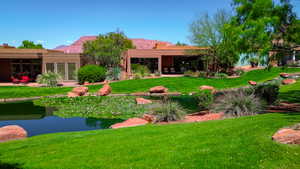 Back of house with a lawn and a mountain view