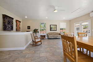 Dining room with baseboards, a ceiling fan, light stone finish floors, recessed lighting, and a wall mounted AC