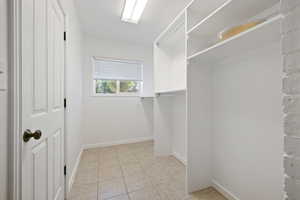 Walk in closet with light tile patterned flooring