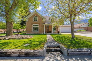 Traditional home featuring brick siding, driveway, and a garage