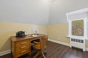 Home office featuring radiator, lofted ceiling, baseboards, and dark wood-style floors