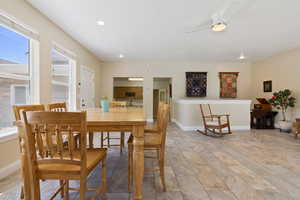 Dining area featuring ceiling fan, light stone finish flooring, baseboards, and recessed lighting
