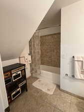 Full bath with tile patterned flooring, shower / bath combo with shower curtain, and baseboards