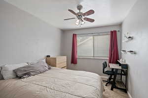 Carpeted bedroom featuring a ceiling fan and baseboards
