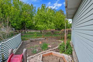 View of yard with a garden and fence