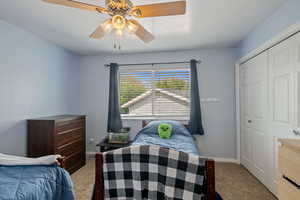 Carpeted bedroom with a closet, ceiling fan, and baseboards