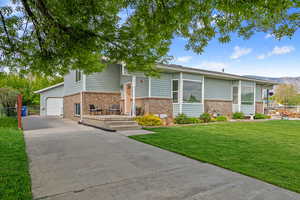View of front facade featuring brick siding, concrete driveway, and a garage
