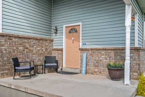 Doorway to property with a patio and brick siding