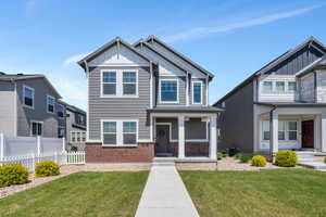 Craftsman inspired home with board and batten siding, brick siding, and covered porch
