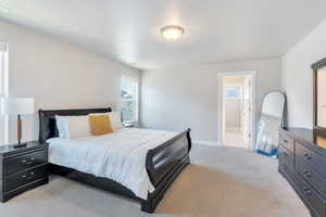 Master suite featuring light carpet and ensuite bath