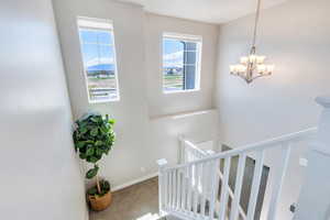 Stairway featuring carpet and a chandelier