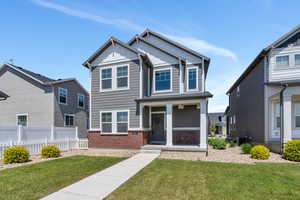 Craftsman inspired home with board and batten siding, brick siding, and covered porch