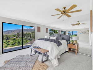 Bedroom featuring access to outside, light colored carpet, a mountain view, a ceiling fan, and baseboards