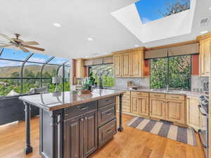 Kitchen featuring a sink, light wood-type flooring, stainless steel electric range, decorative backsplash, and recessed lighting