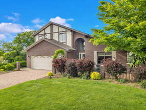 View of front facade featuring brick siding and driveway