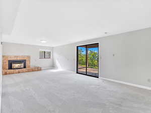 Unfurnished living room with a fireplace, carpet flooring, and baseboards