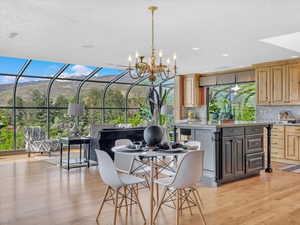 Dining room with light wood-style floors, a chandelier, and recessed lighting