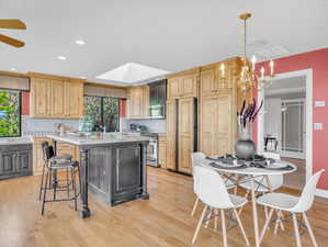 Kitchen featuring stainless steel appliances, a chandelier, a kitchen island, tasteful backsplash, and recessed lighting