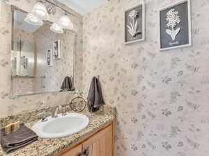 Bathroom with vanity and wallpapered walls