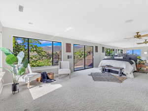 Carpeted bedroom featuring access to outside, multiple windows, a ceiling fan, and baseboards