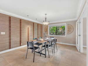 Dining area with baseboards, light tile patterned flooring, and crown molding