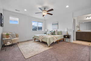 Bedroom featuring light colored carpet, recessed lighting, a ceiling fan, baseboards, and ensuite bathroom