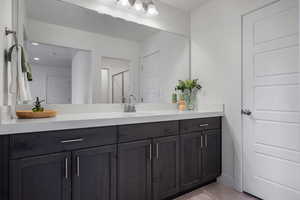 Full bathroom featuring vanity, a stall shower, tile patterned flooring, and baseboards