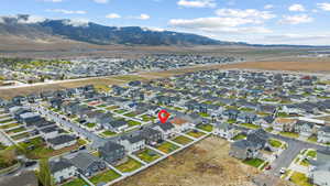 Aerial view of property and surrounding area with nearby suburban area and a mountain backdrop