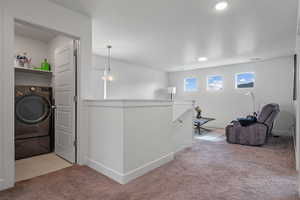 Hallway with washer / dryer, an upstairs landing, carpet flooring, baseboards, and recessed lighting