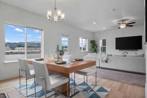 Dining room with a mountain view, a chandelier, recessed lighting, light wood-type flooring, and a ceiling fan