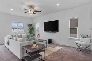 Living area with light colored carpet, a ceiling fan, recessed lighting, and baseboards