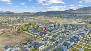 Aerial overview of property's location with a mountain backdrop and nearby suburban area
