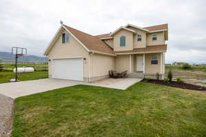 View of front of property with a shingled roof, concrete driveway, a front lawn, and a mountain view