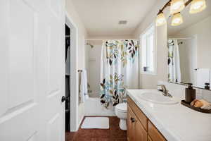 Master Bathroom with vanity, shower / tub combo, tile patterned flooring, and toilet & Walk In Closet