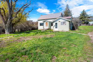View of front facade featuring metal roof and a front lawn
