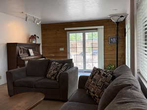 Living room featuring wood walls and rail lighting