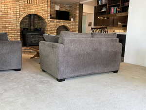 Living area featuring carpet flooring and a wood stove