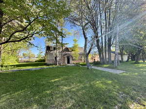 View of front of property featuring stone siding and a front lawn