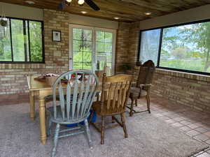 Sunroom featuring brick wall, healthy amount of natural light, wooden ceiling, and recessed lighting