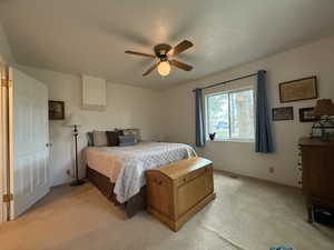 Bedroom with light carpet and a ceiling fan