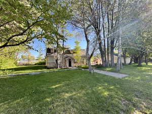 View of front facade featuring a front lawn and stone siding