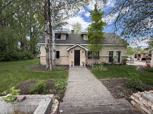 View of front of home featuring stucco siding, a patio, a front lawn, and brick siding