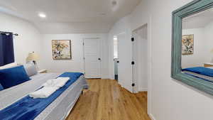 Bedroom featuring vaulted ceiling, light wood-type flooring, recessed lighting, and baseboards