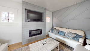 Living area featuring wood finished floors, baseboards, and a fireplace