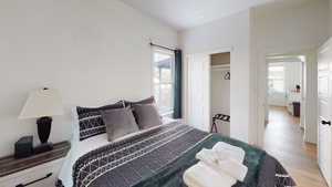 Bedroom with light wood-style flooring, washer / clothes dryer, and a closet