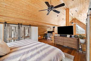 Bedroom with wood ceiling, lofted ceiling, dark wood-style floors, and a barn door