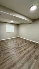Finished basement with baseboards and wood finished floors