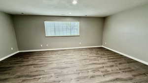 Unfurnished room with wood finished floors, baseboards, and recessed lighting